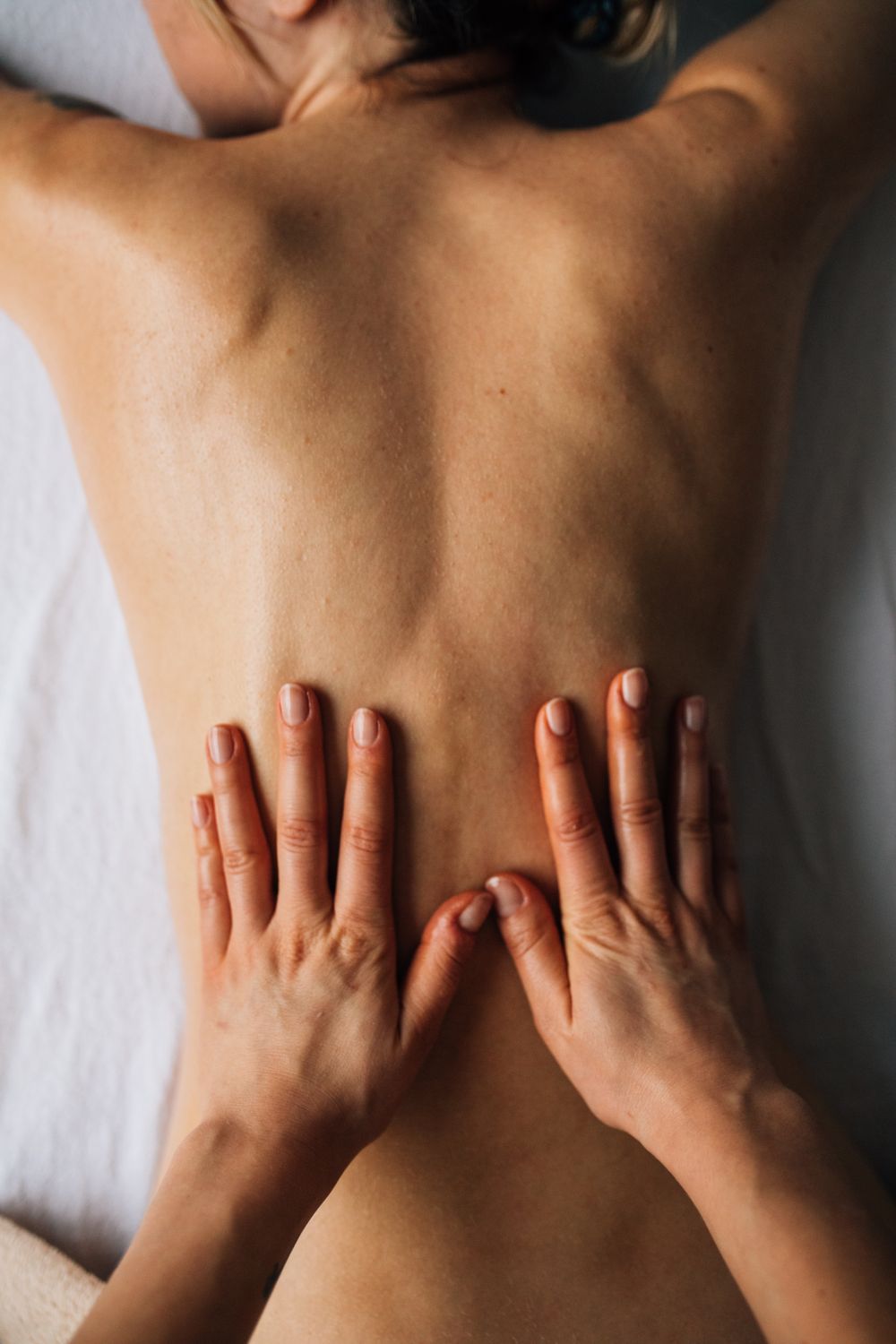 Therapist working along a guest's shoulder during a treatment